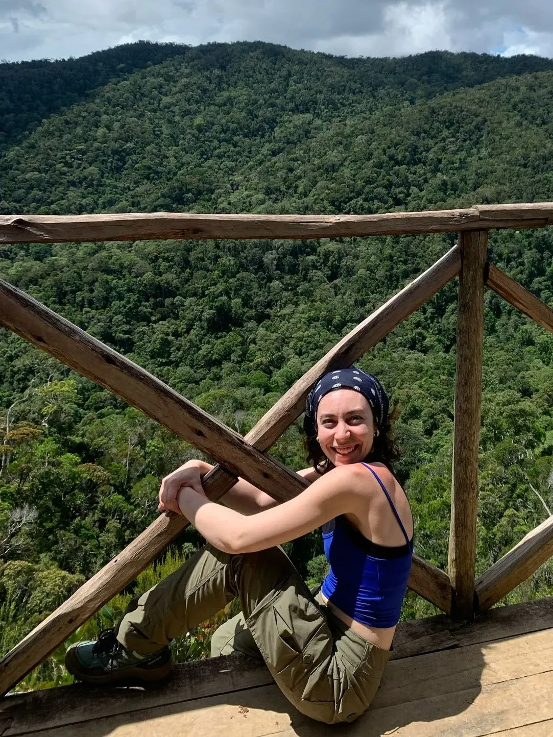 Gaia Caravella. Image credit - Eleanor Hesketh. A person leaning on a railing with a forest view in the background