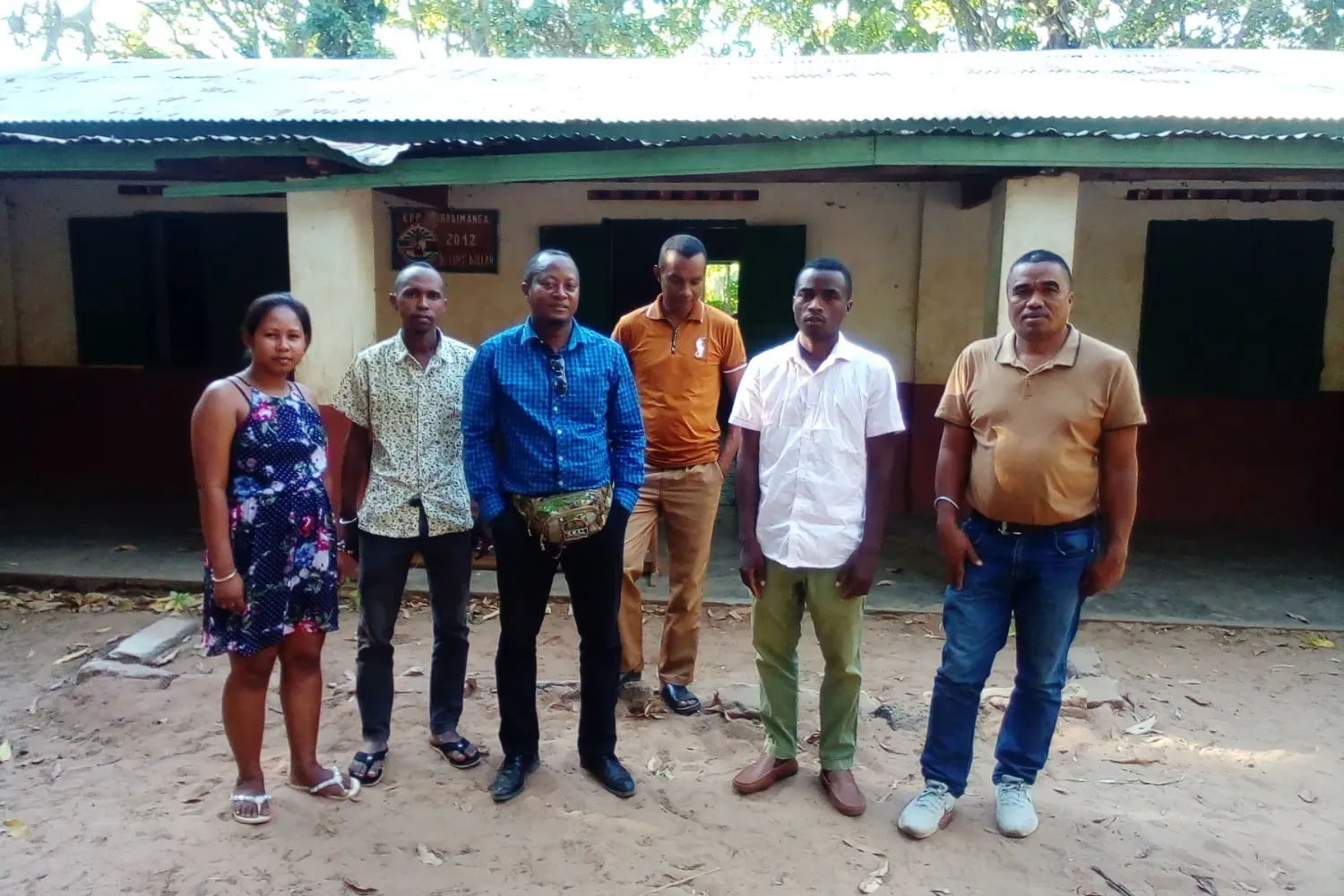 Educators supporting environmental learning at Ambodimanga Primary School A group of six teachers and community members stand outside a rural school building in Madagascar.