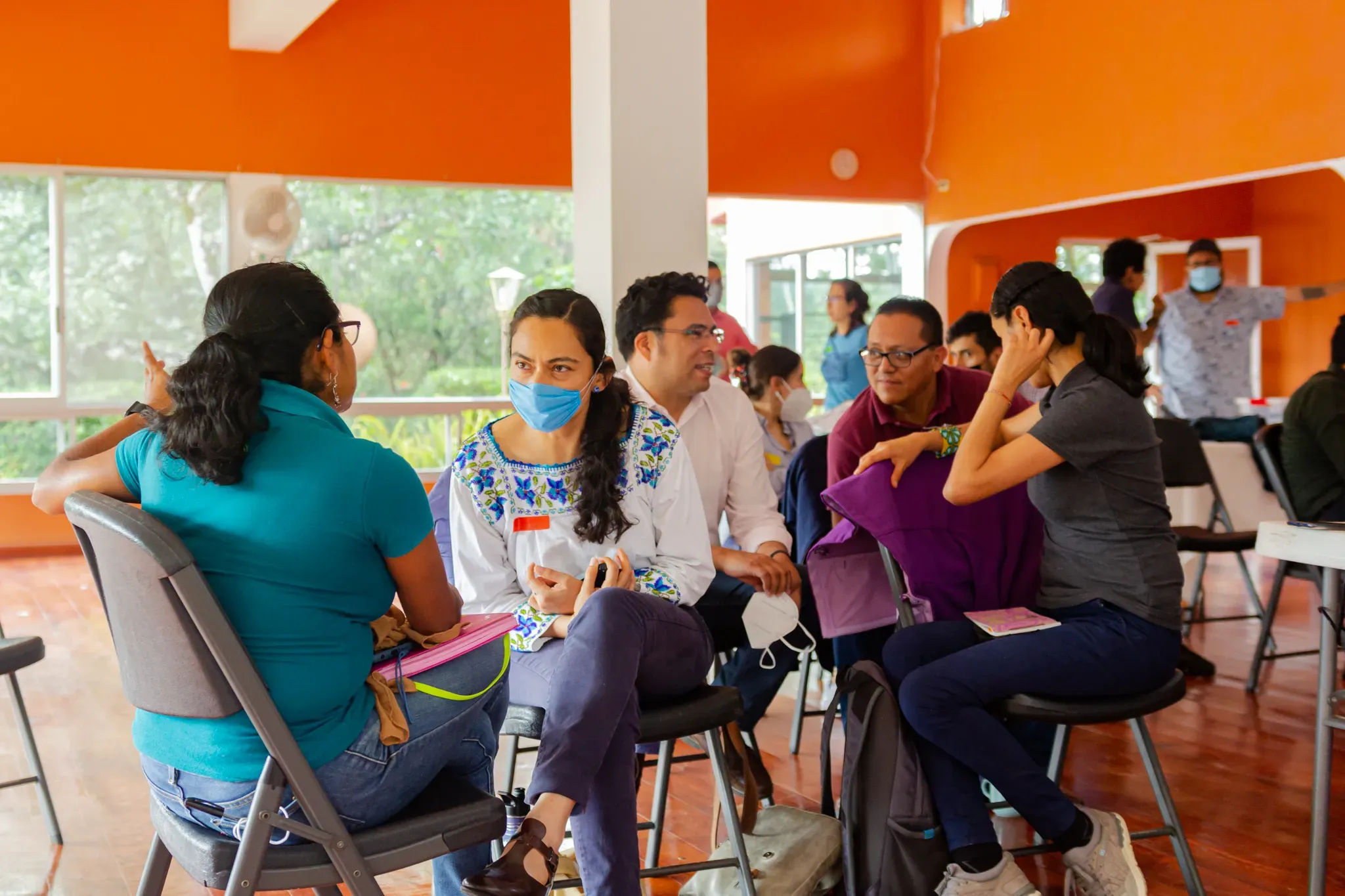 Collaborative learning: Women farmers and local partners engage in group discussions during a shade-grown coffee workshop on native tree species selections © Alejandro Guerrero A group of training participants share discussions in a large open room