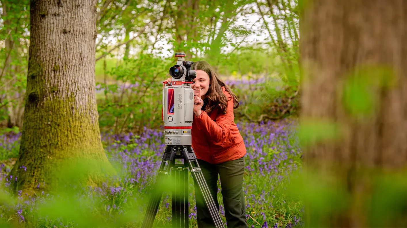 LiDAR scanning, Jim Holden © RBG Kew A scientist stands in a field of bluebells, next to a LiDAR scanner