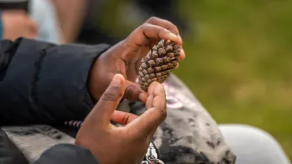 Sow and Grow at Wakehurst Boy holding a pine cone